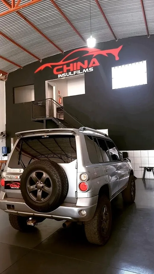 Utilitário prata com película, vista traseira